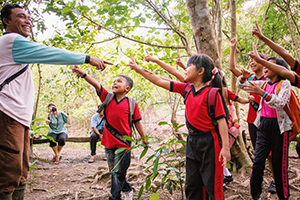 Teacher talking to students about rainforest conservation