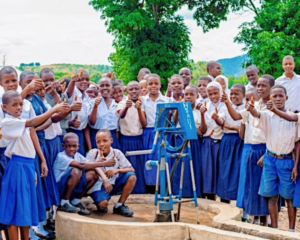 People gathered around water pump